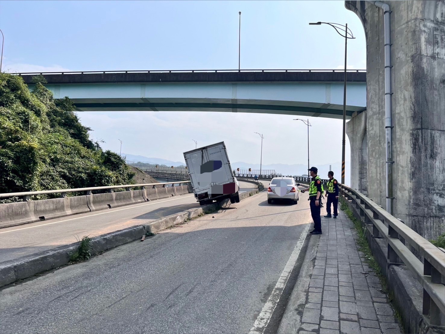 基隆貨車自撞分隔島！半台車「懸空卡路中」　警方急到場駕駛竟消失了